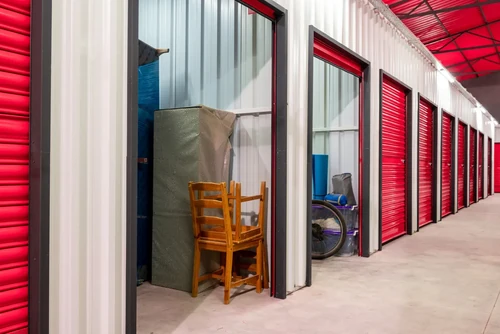 Corridor of climate-controlled self storage units with red doors. Rental Storage Units